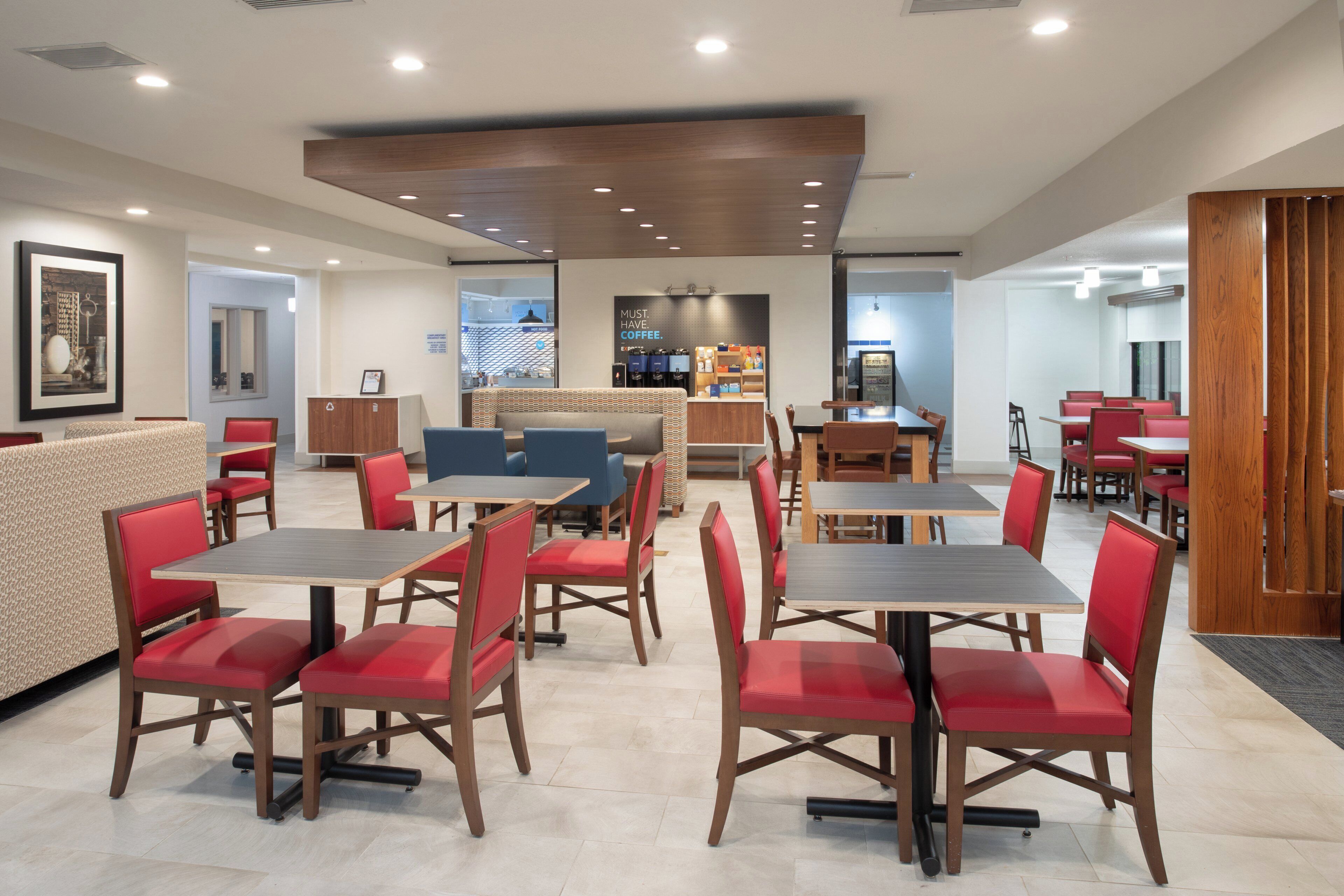 A modern restaurant with booths and tables, a coffee bar, and a counter.