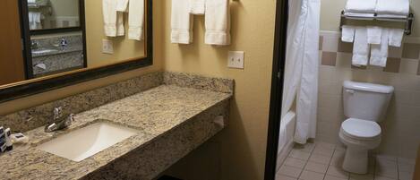 A bathroom with a granite countertop sink, a mirror, a toilet, and a shower curtain.