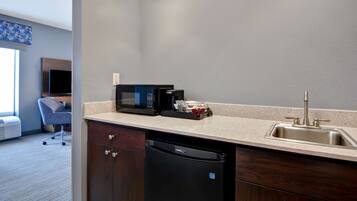 A modern kitchen with a built-in microwave, coffee maker, and dishwasher.