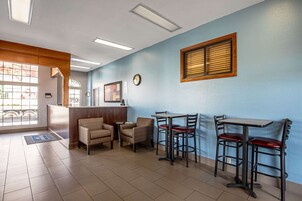 Interior de un restaurante con mostrador de recepción, dos cabinas y una zona de bar.