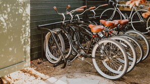 Bicicletas estacionadas junto a una pared de madera en un espacio cubierto con piso de baldosas.