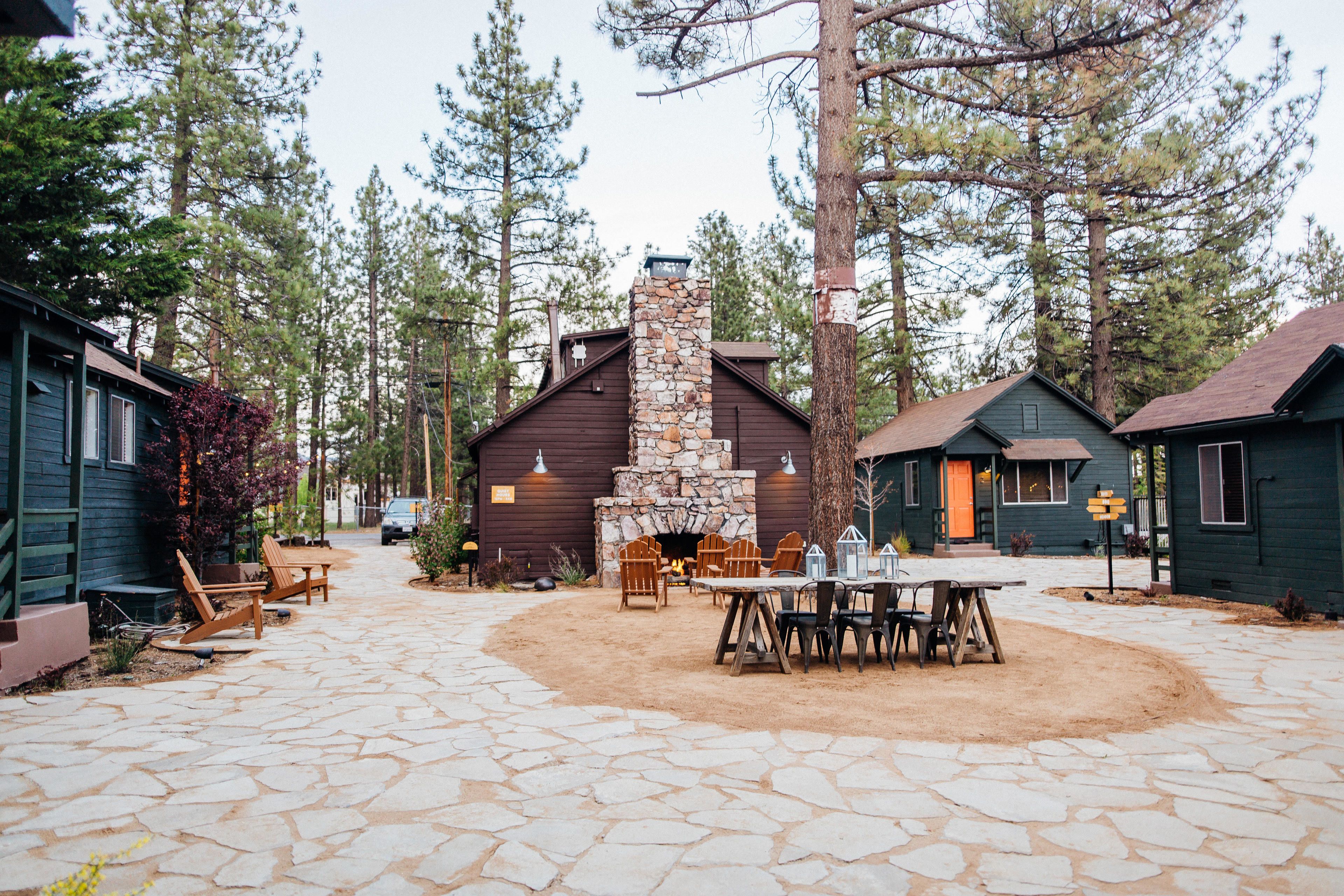 A stone patio with outdoor seating and a stone fireplace.