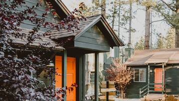 Experience the charm of a rustic cabin-style building surrounded by a serene courtyard and lush foliage.