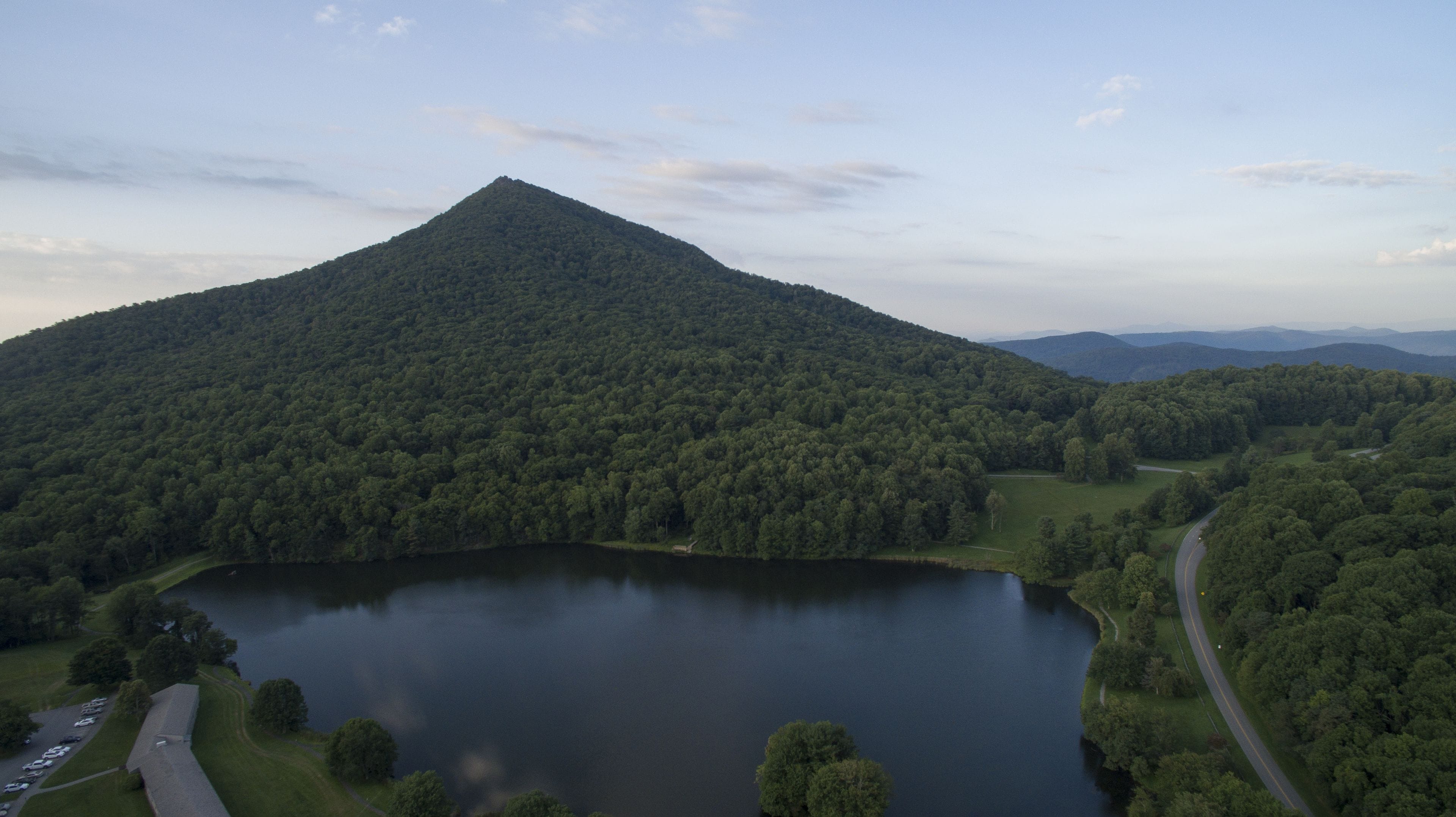 Un paisaje montañoso con un lago y una carretera.