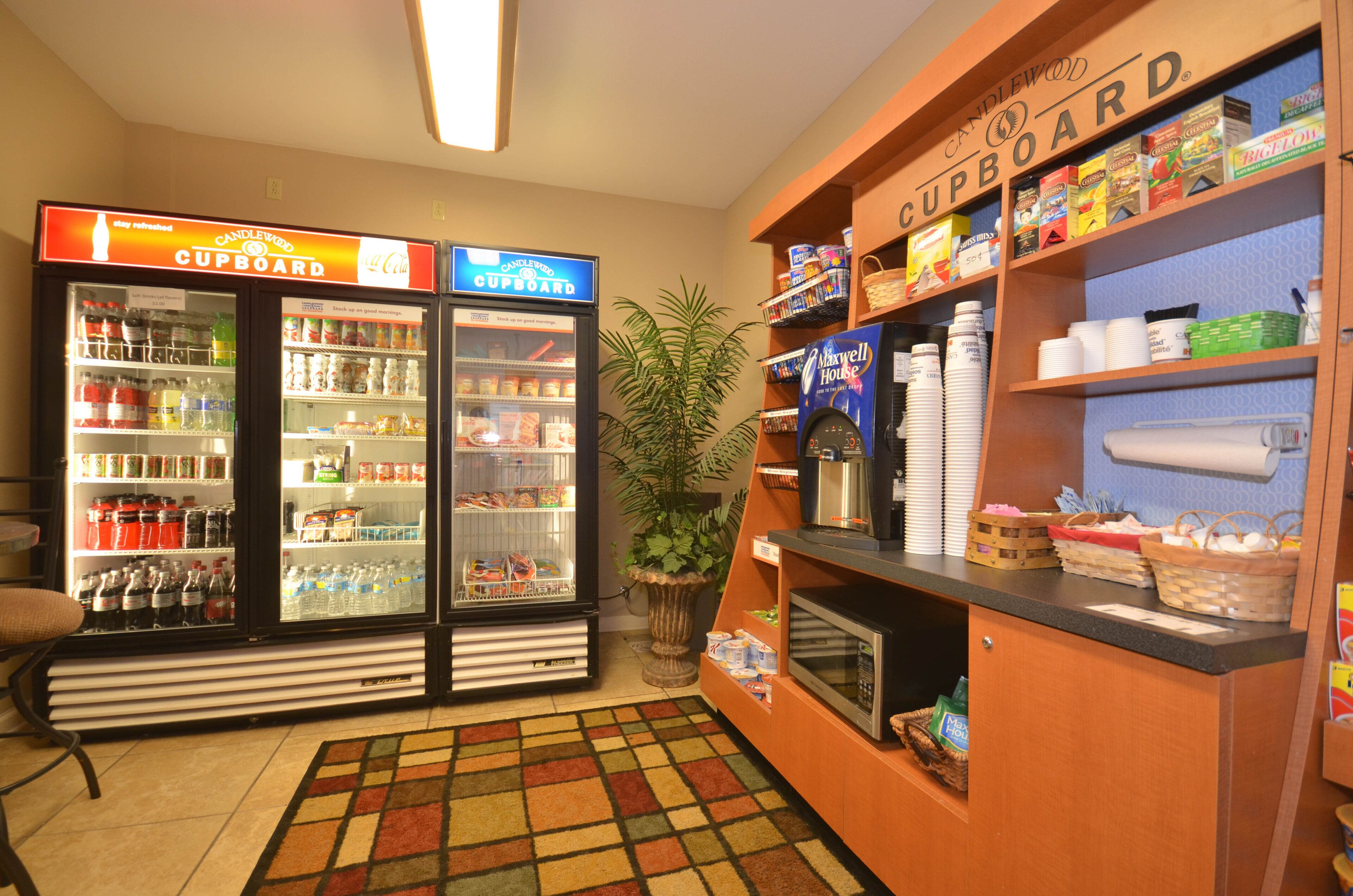 A kitchenette area with a refrigerator stocked with beverages, a microwave, and a coffee maker.