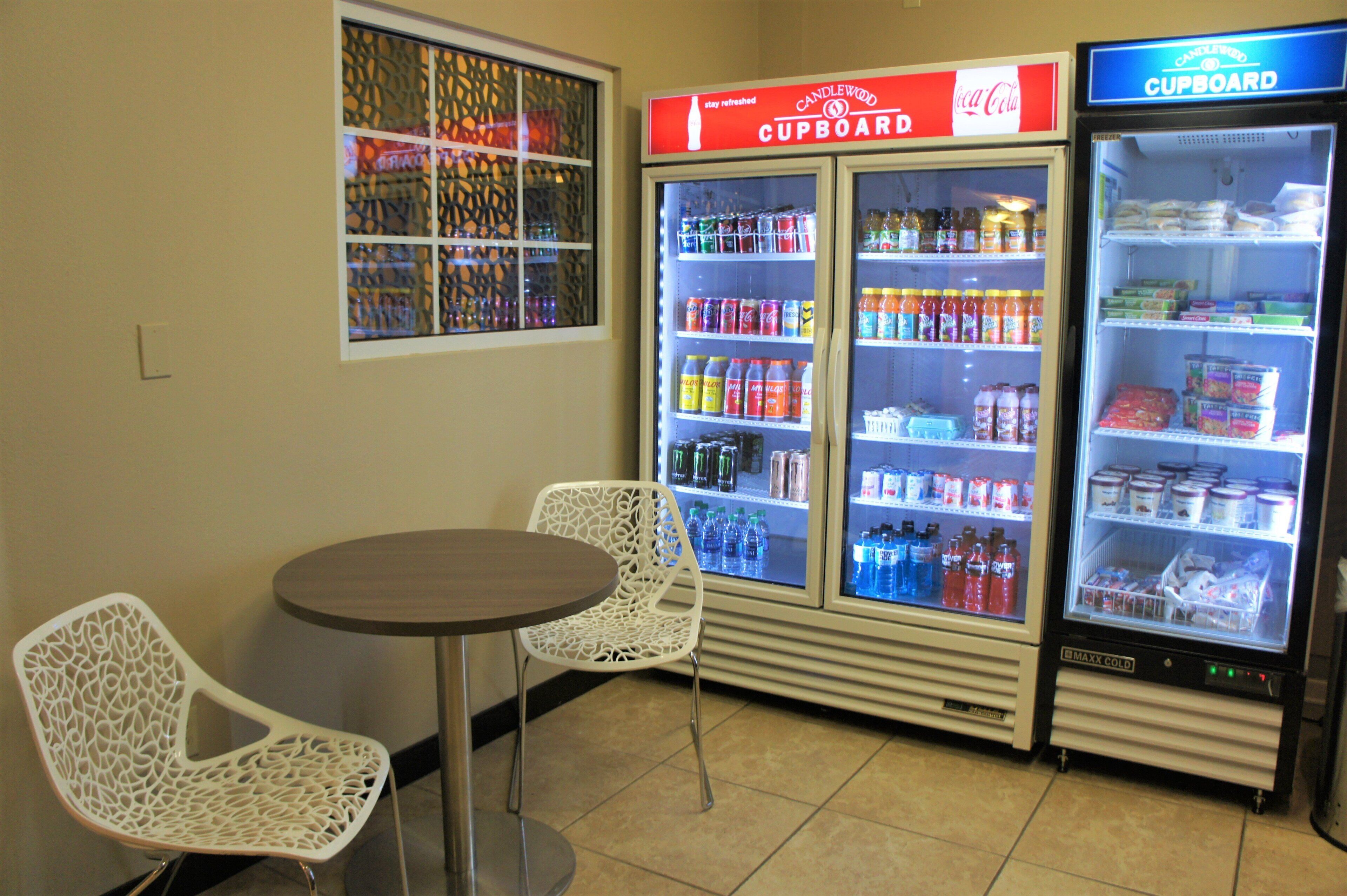 Un área de venta con dos dispensadores de bebidas, una mesa y dos sillas.