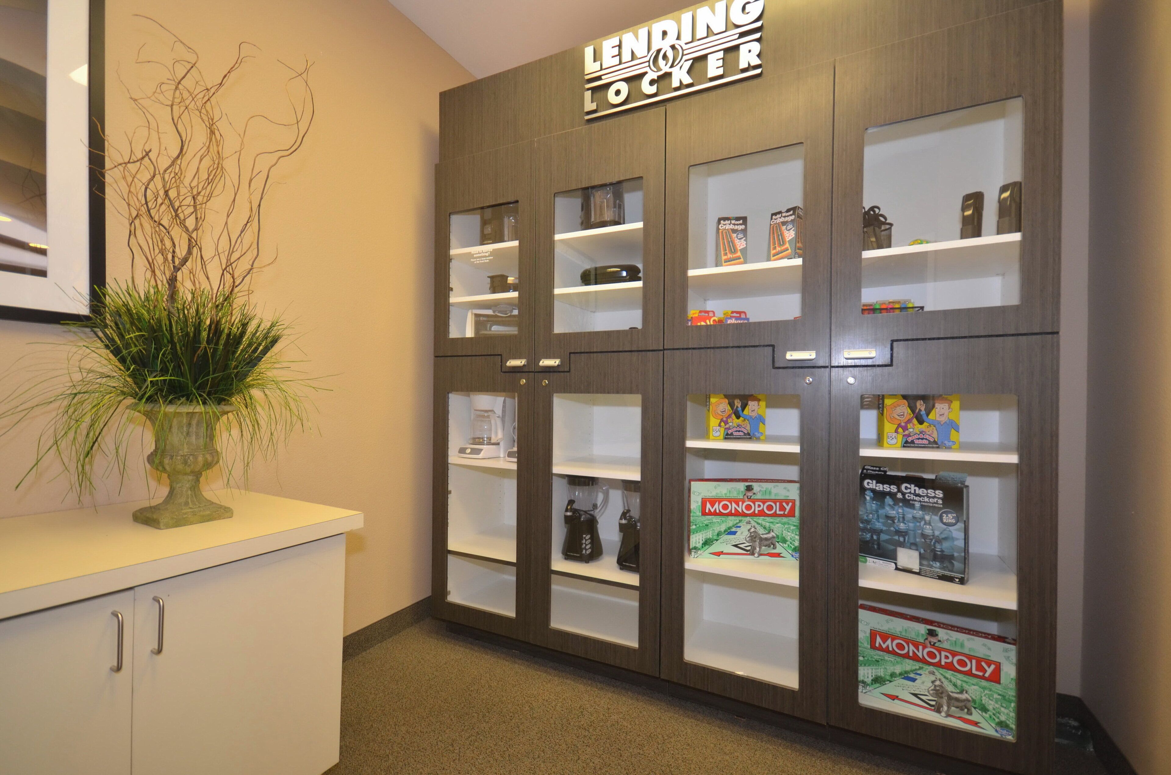 A storage area with labeled compartments, a coffee maker, and board games like Monopoly.