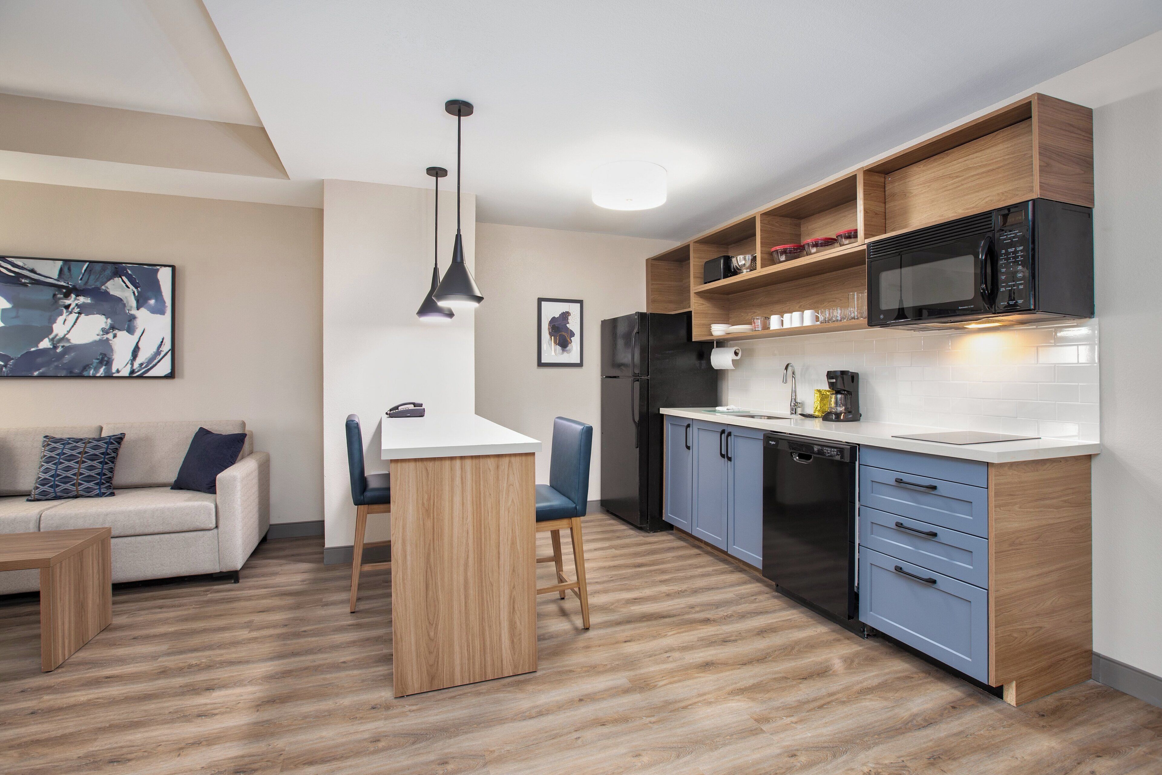 A modern kitchen with wooden cabinets, a built-in microwave, and a dishwasher.