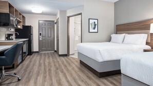 A hotel room with a bed, a desk, a chair, a microwave, and a refrigerator. - Candlewood Suites Conway by IHG (Conway)