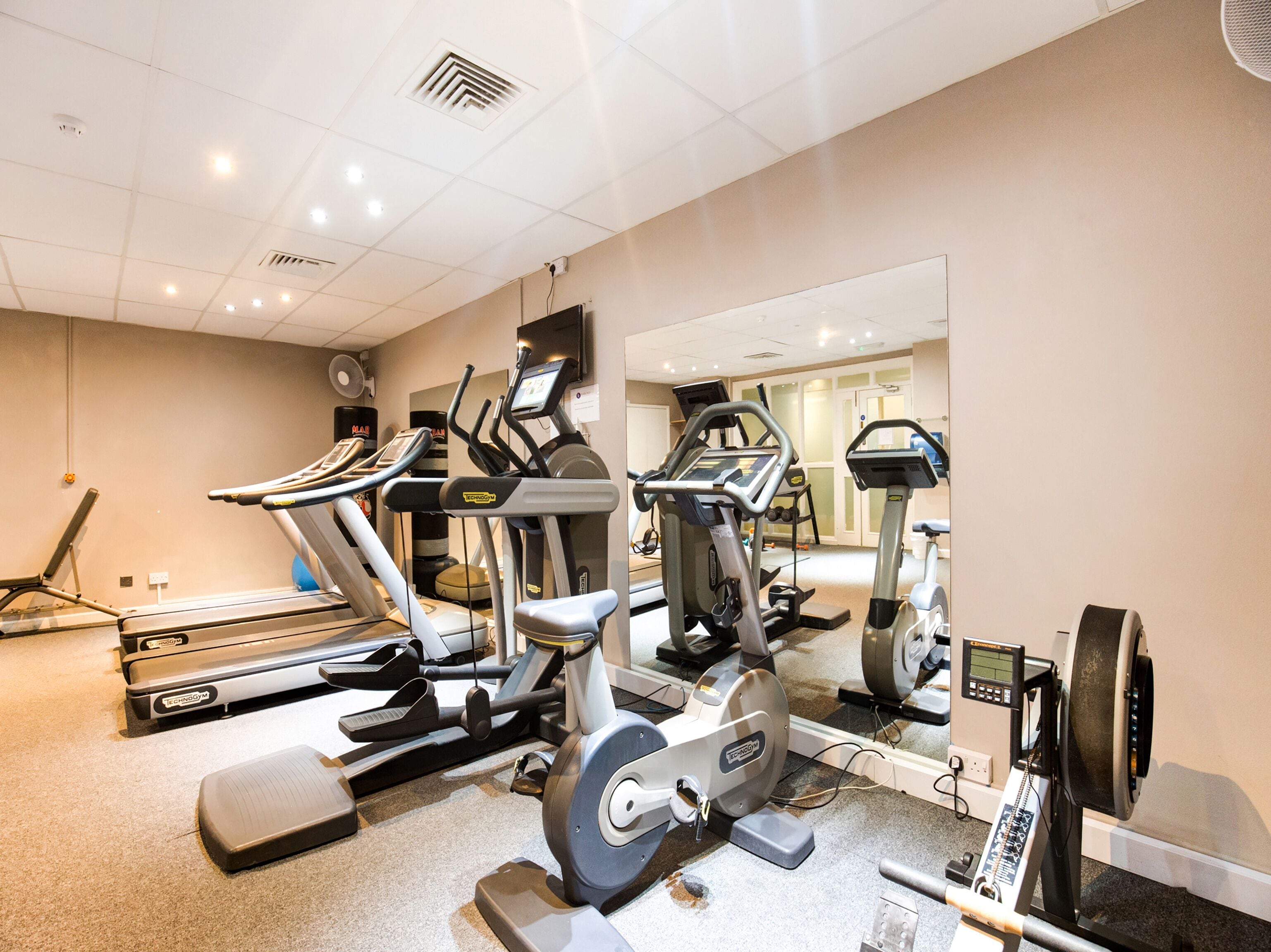 A gym with treadmills, elliptical machines, and a stationary bike.