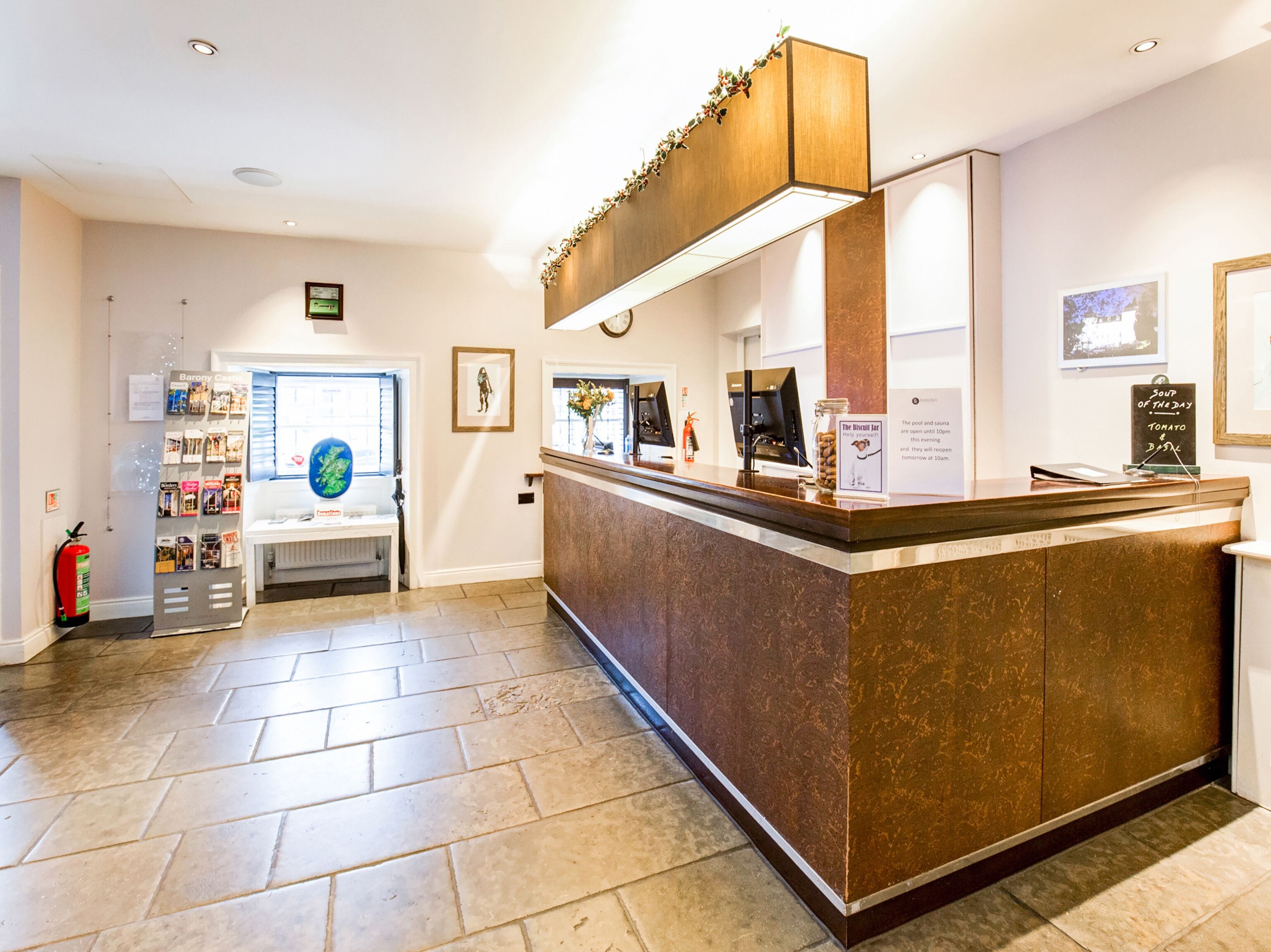 A reception area with a marble counter, framed artwork on the walls, and a fire extinguisher near the entrance.