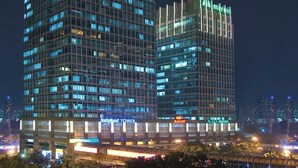 Ein Hochhaus mit modernem Design, das durch einen markanten, vertikalen Lichtstreifen an der Fassade hervorgehoben wird.