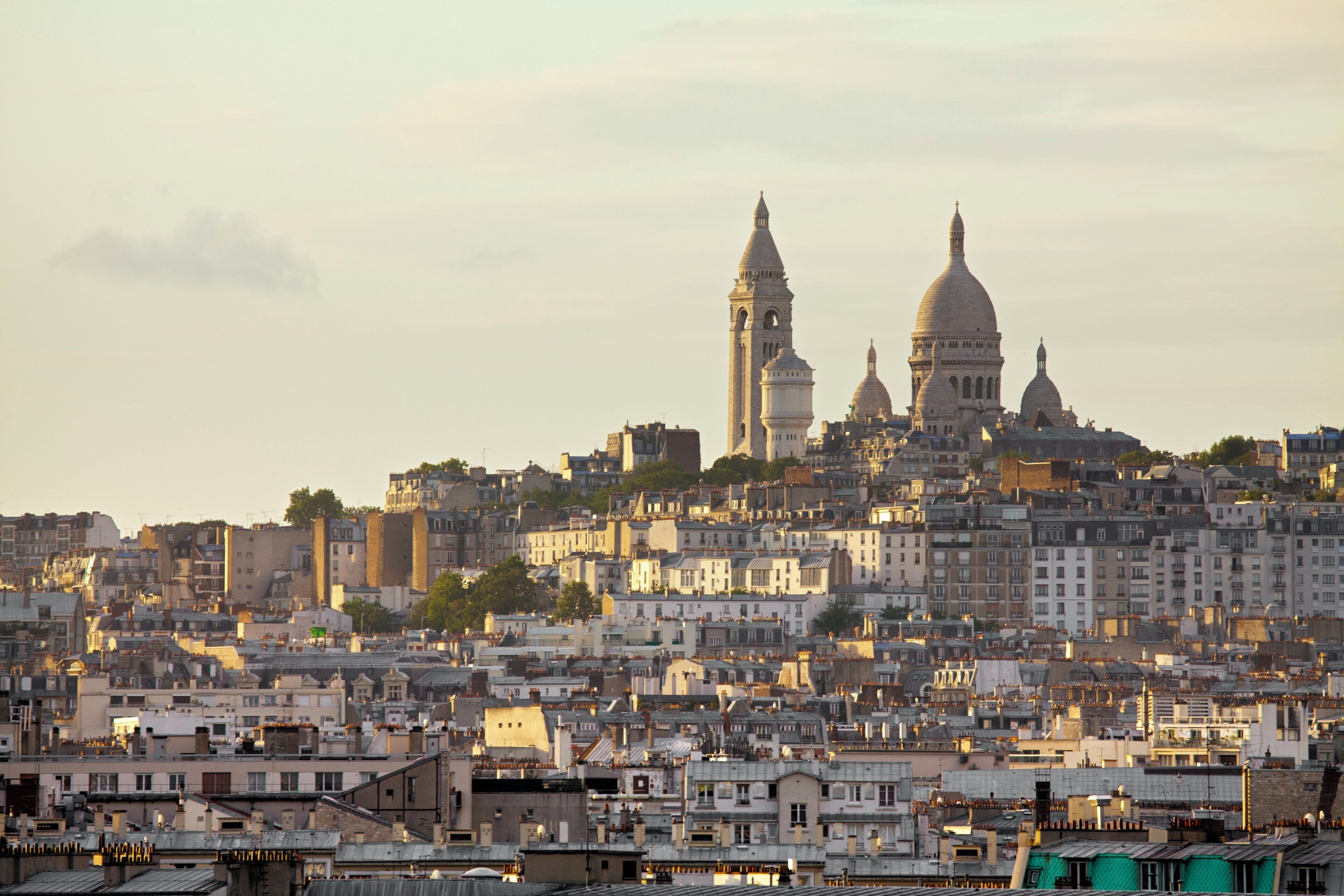 A cityscape with a prominent cathedral featuring two domes and a tall bell tower.