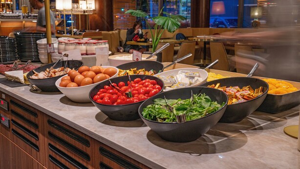 A buffet with various food items including eggs, tomatoes, and salads. - voco Paris – Porte de Clichy by IHG (Clichy)