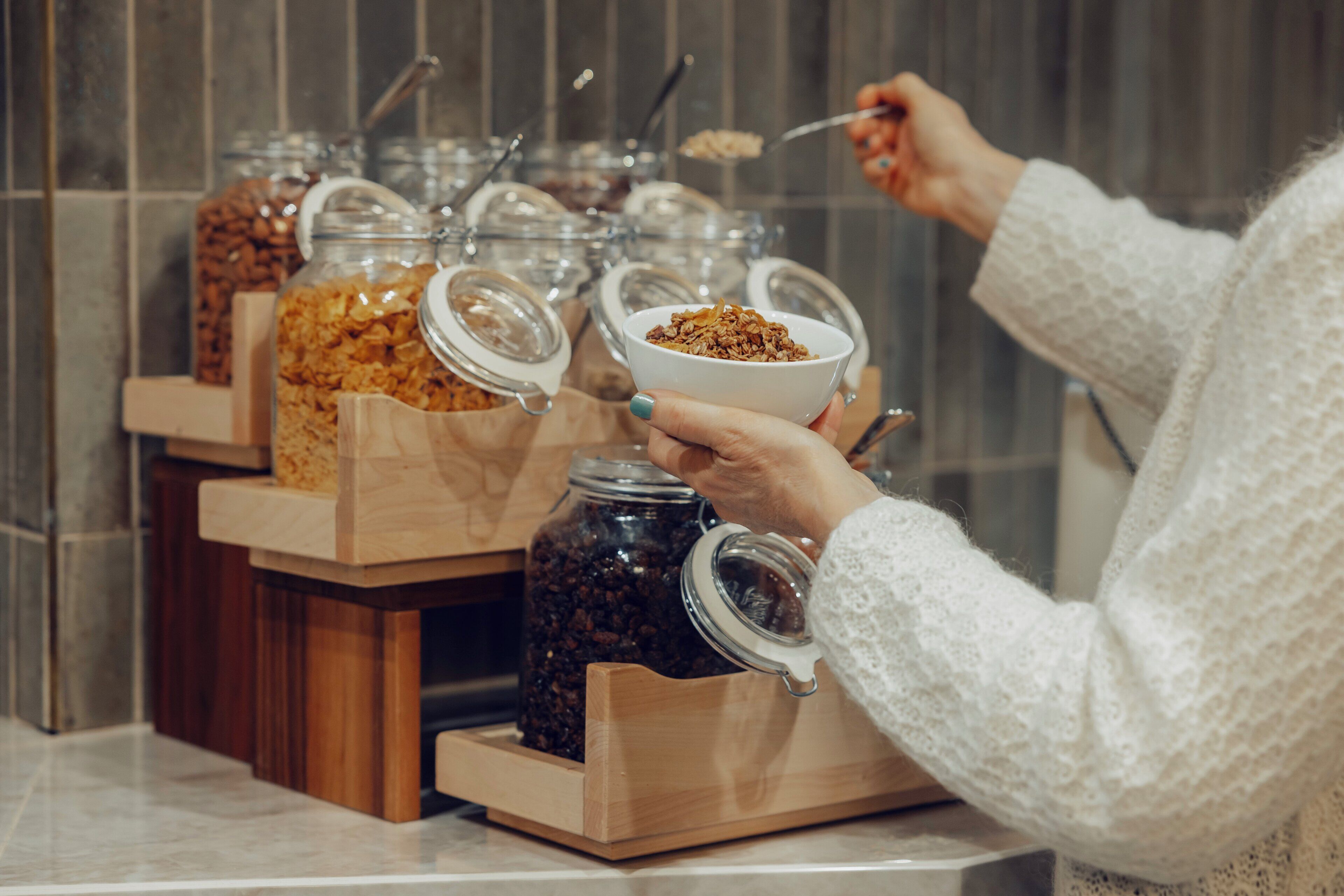 A buffet setup with various food items in glass containers.