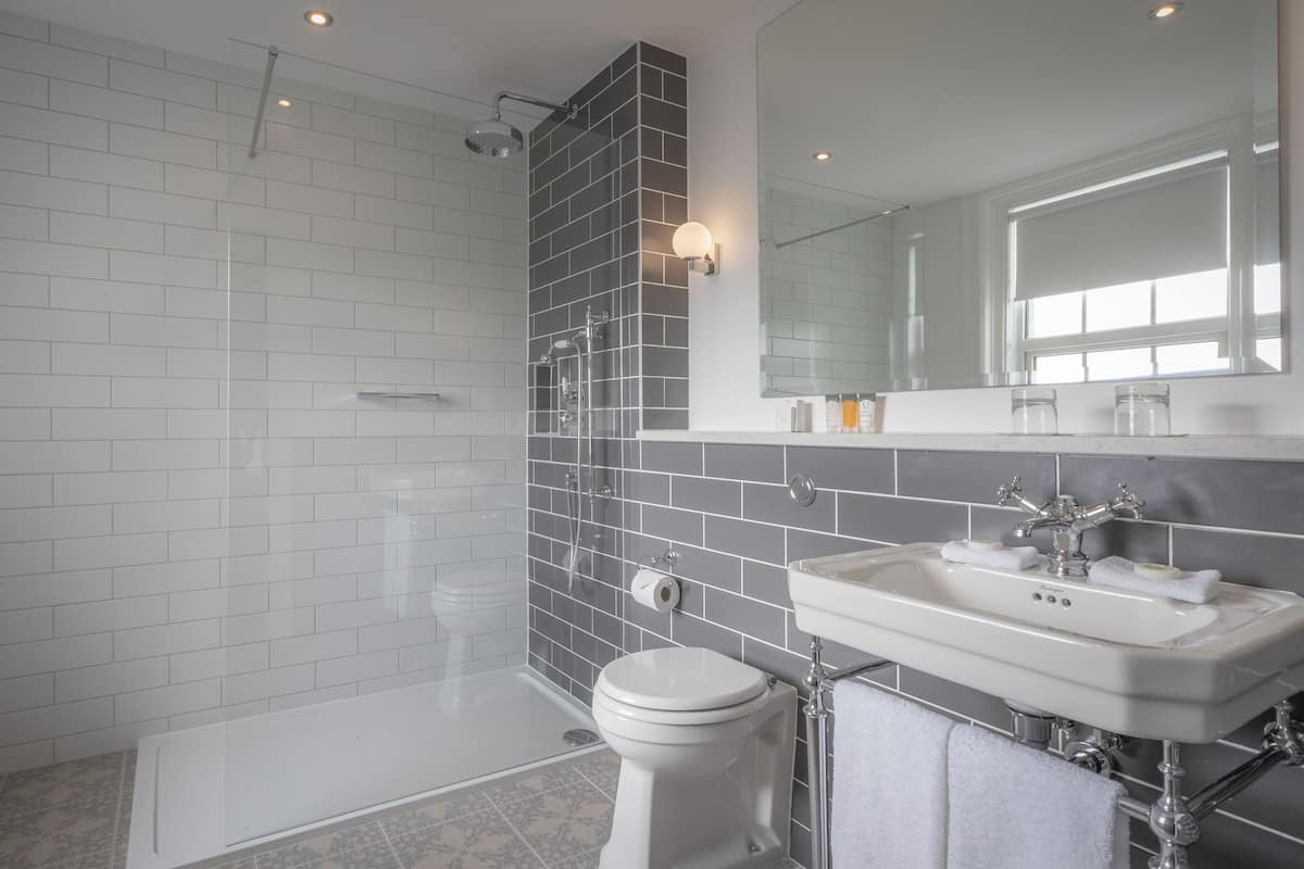 A modern bathroom with a shower, toilet, and sink.
