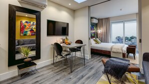 Una habitación de hotel moderna con comedor, cama y vistas al balcón.