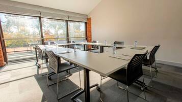 A conference room with a long table, chairs, and water bottles.