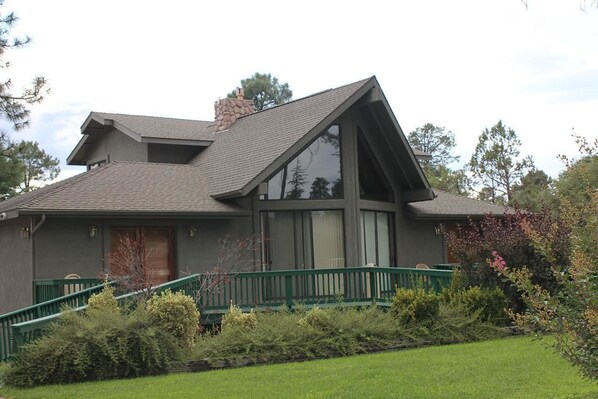 A two-story house with a sloped roof, large windows, and a green front porch. - Majestic Mountain Inn (Payson)