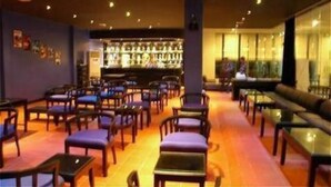 A hotel lobby with rows of seating, a bar area, and a reception desk. - Orient D'angkor (Siem Reap)