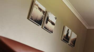 A staircase with a brown handrail and three framed photographs on the wall.