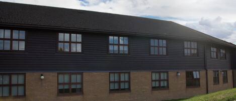 A two-story building with a dark exterior and multiple windows.