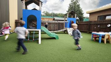 Children can play on the slide and climbing elements in this secure play area.