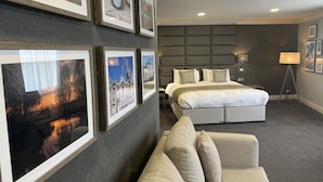 Ein Hotelzimmer mit einem großen Bett, einer Couch und mehreren gerahmten Bildern an der Wand.