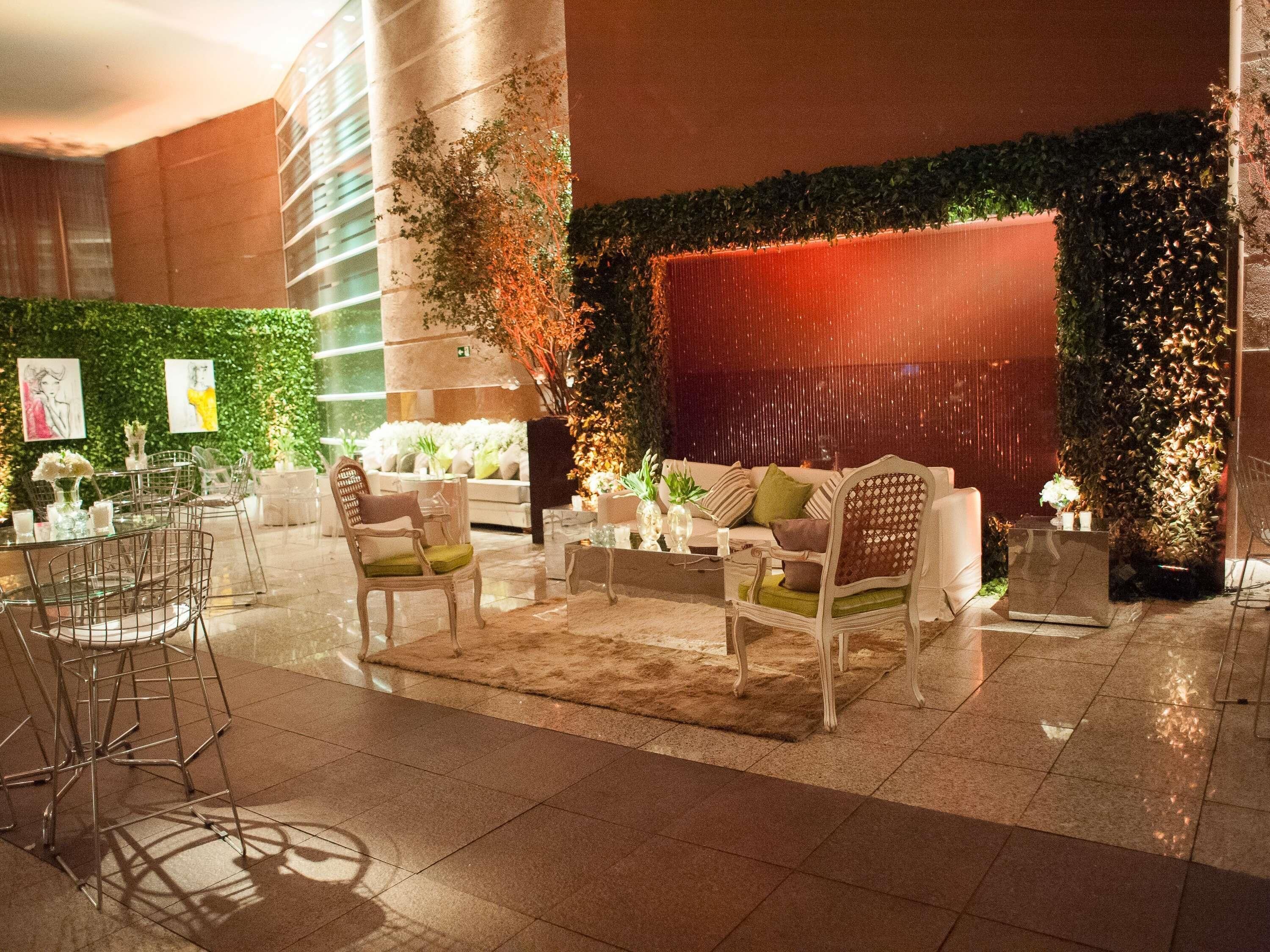 A modern lobby with a seating area, a bar, and a green wall with plants.