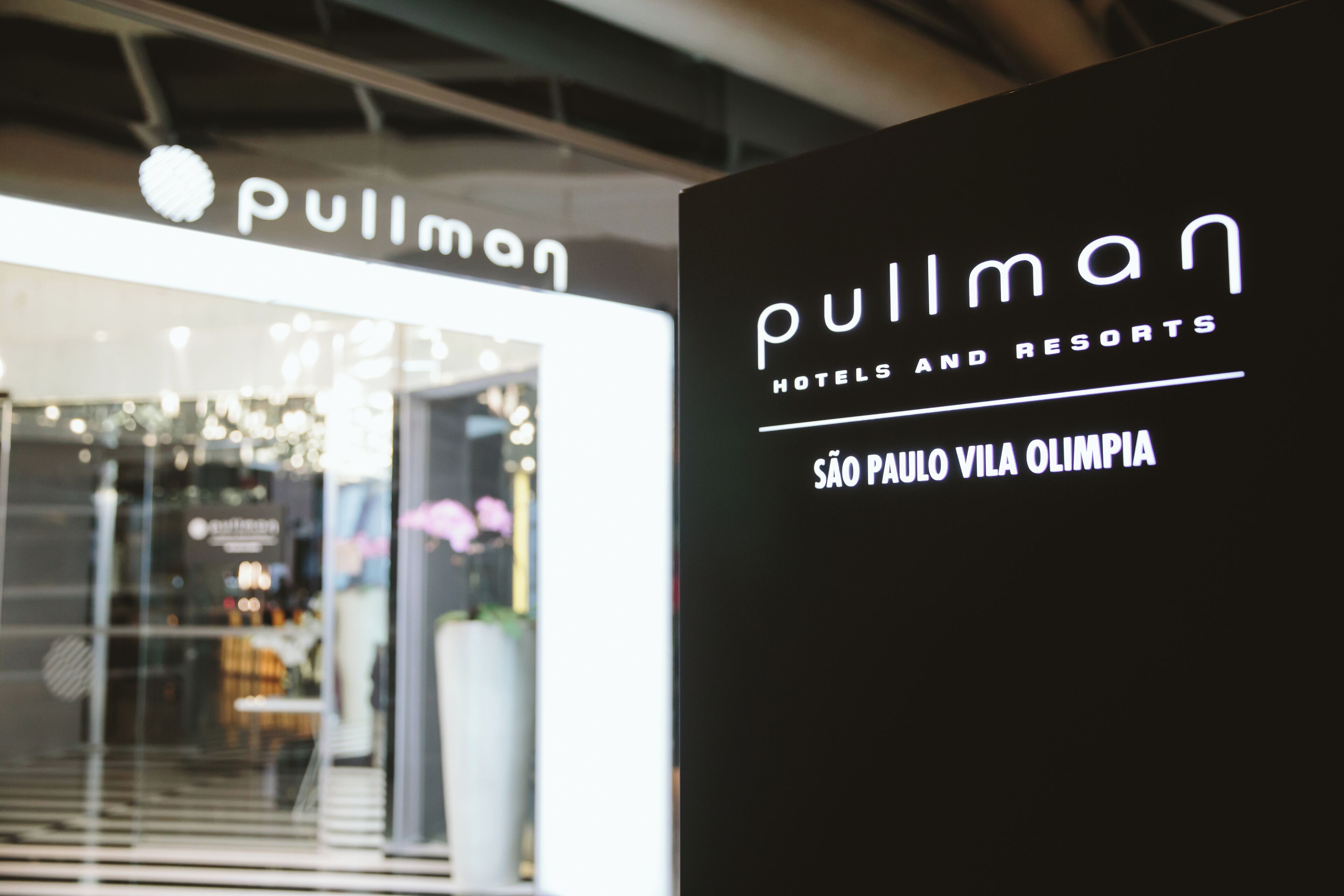 A hotel sign with the name 'Pullman Hotels and Resorts' and the location 'São Paulo Vila Olímpia'.