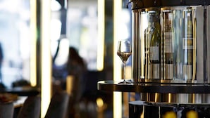 Zona de bar con una botella de vino y una copa.