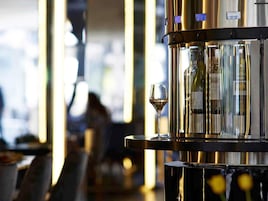 Zona de bar con una botella de vino y una copa.