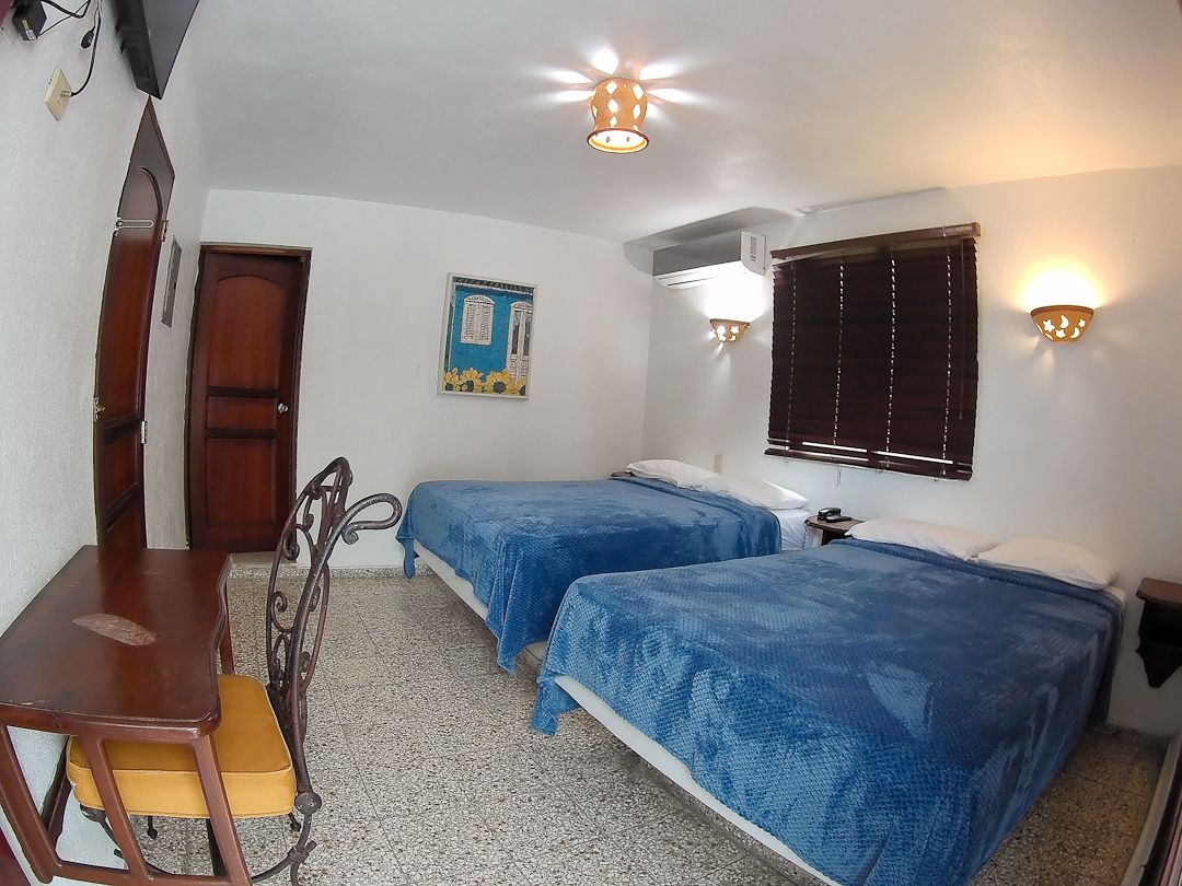 A room with two beds, a desk, and a chair.