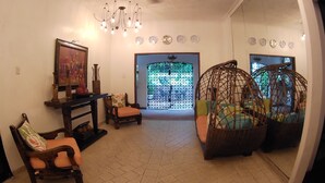 Ein Wohnzimmer mit Kamin, Deckenventilator und einem großen Spiegel, der den Raum reflektiert.
