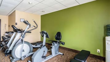 A gym with exercise equipment, a bench, and a water dispenser.