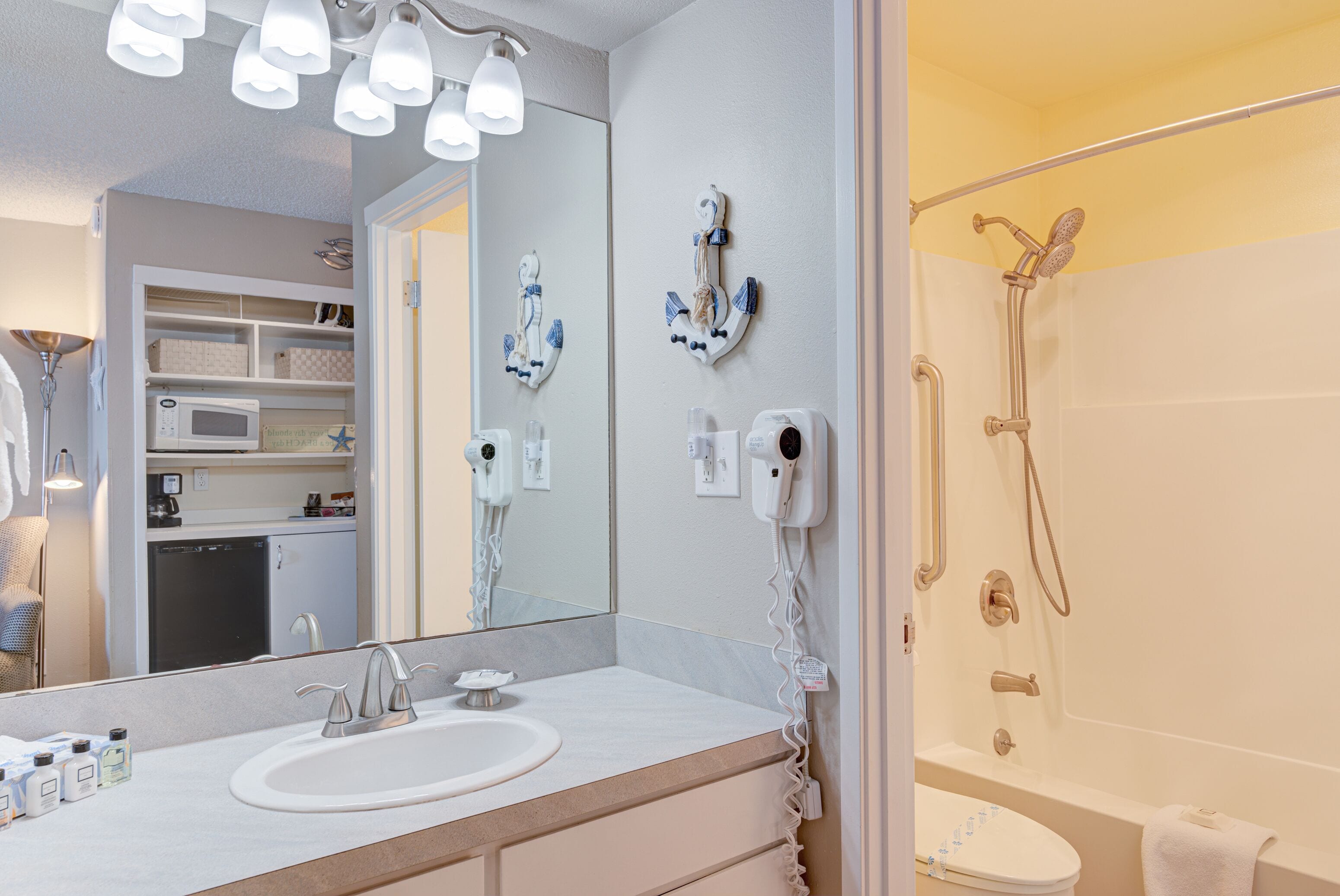 Un baño moderno con lavamanos, espejo y ducha.