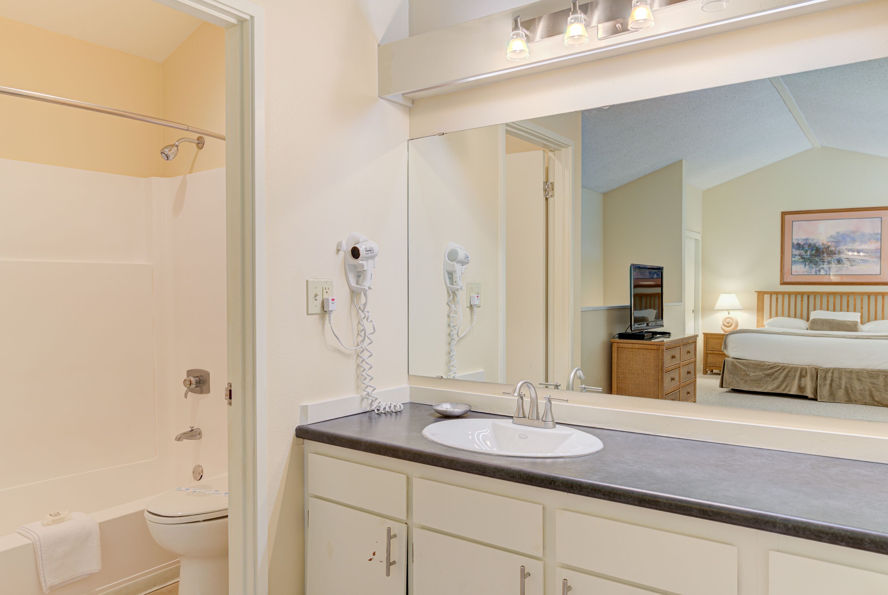 Une salle de bain avec un lavabo, un miroir et une douche.