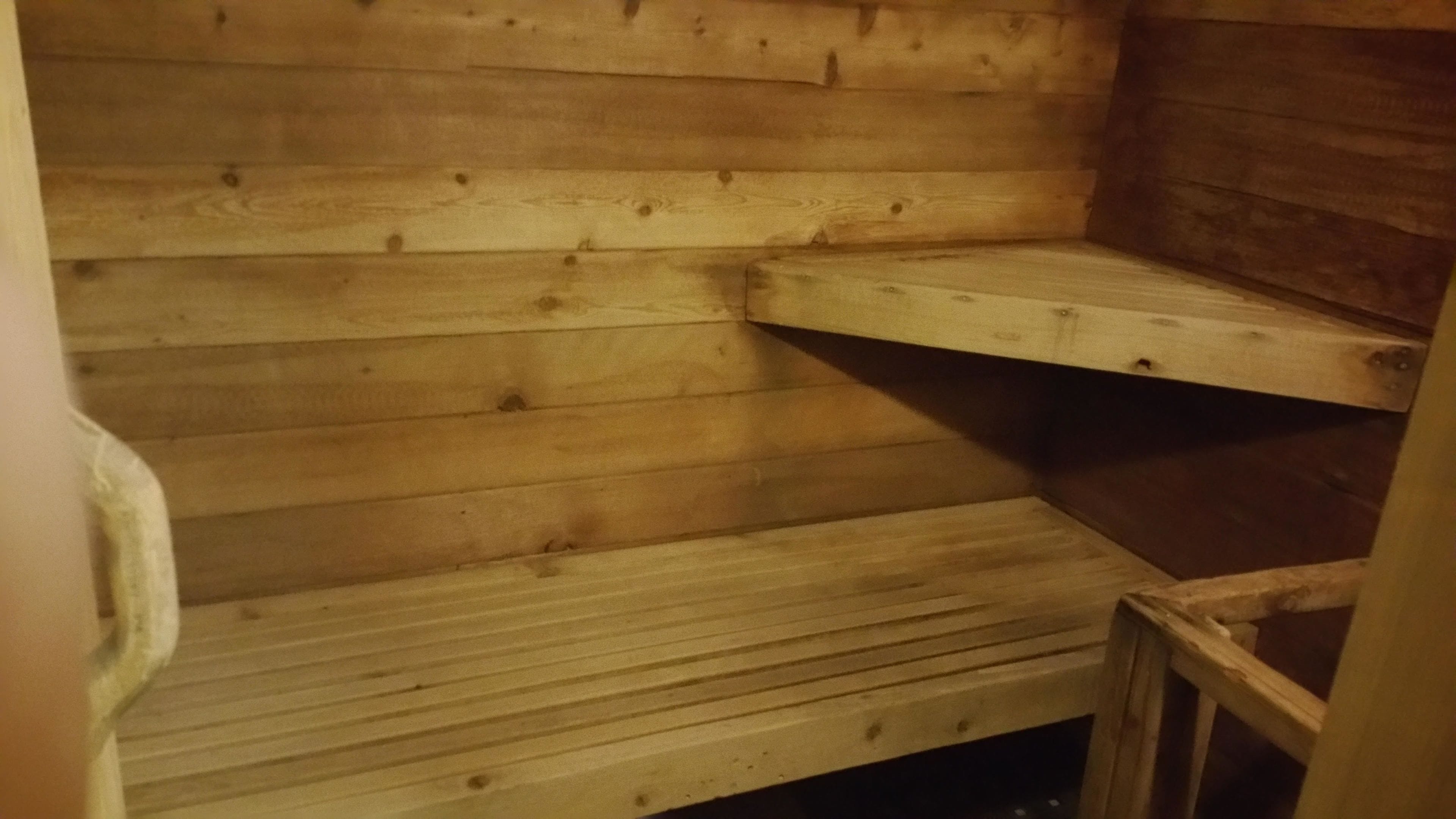 Un interior de madera con un banco empotrado y un estante bajo.