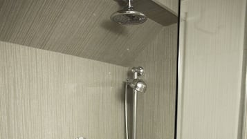 A modern shower with a handheld showerhead and a fixed overhead showerhead.
