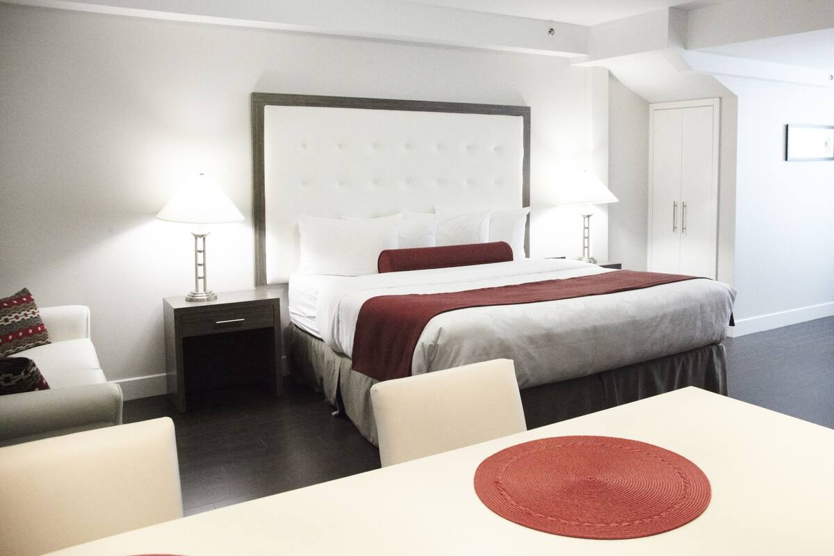 Una habitación de hotel con cama, mesitas de noche, escritorio y una silla.