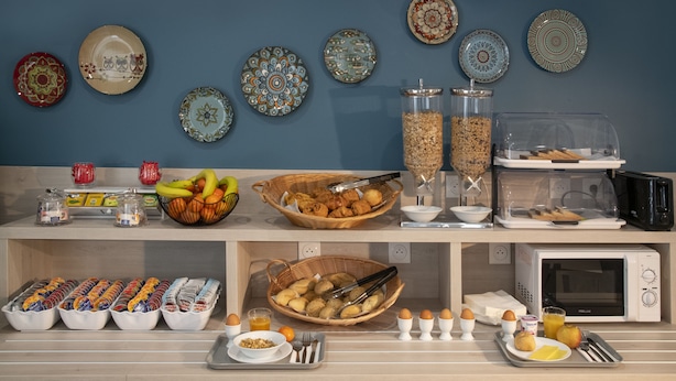 Un bufé de desayuno con diversos alimentos y acompañamientos.