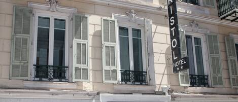 Un hotel con fachada clásica, ventanas amplias y un cartel llamativo del Hotel Bristol.