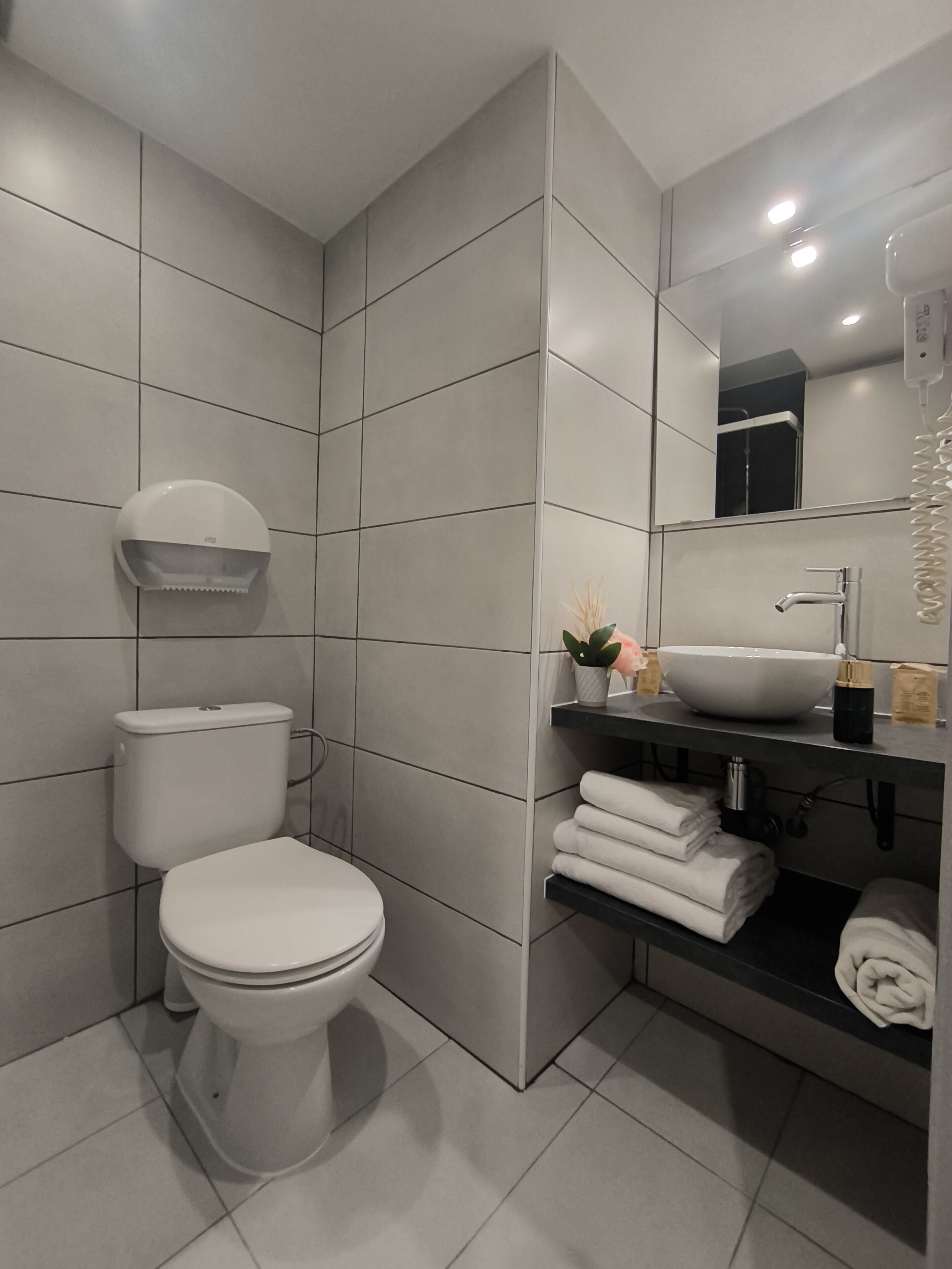 A modern bathroom with a toilet, sink, and towel rack.