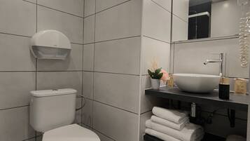 A modern bathroom with a toilet, sink, and towel rack.