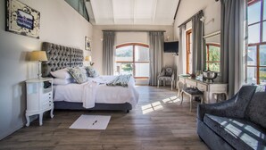 Une chambre à coucher avec un grand lit, un bureau, une chaise et un canapé.
