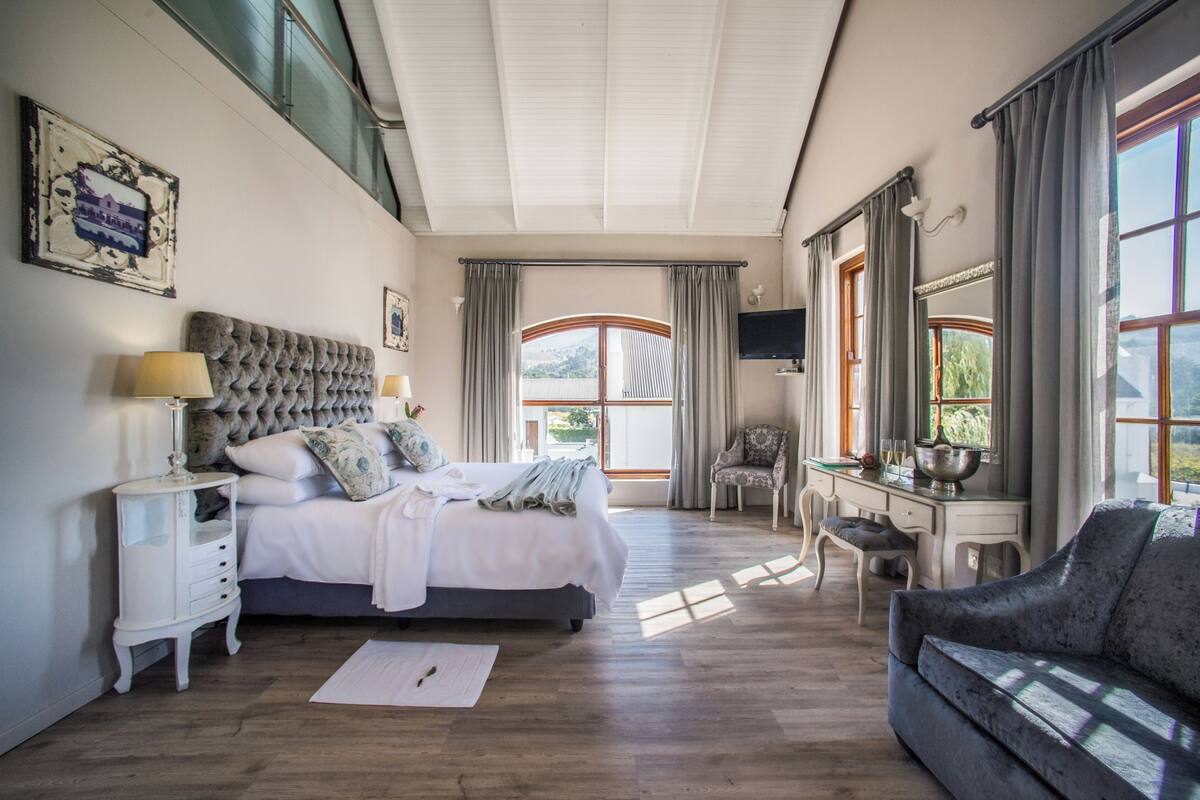 Une chambre à coucher avec un grand lit, un bureau, une chaise et un canapé.