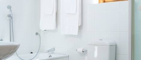 A bathroom with a black and white checkered floor, a white toilet, a white sink, and a shower with a glass door.