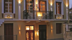 A two-story building with a balcony, a sign reading "Aftoma," and a door with a decorative glass panel. - Aetoma Hotel (Nafplio)