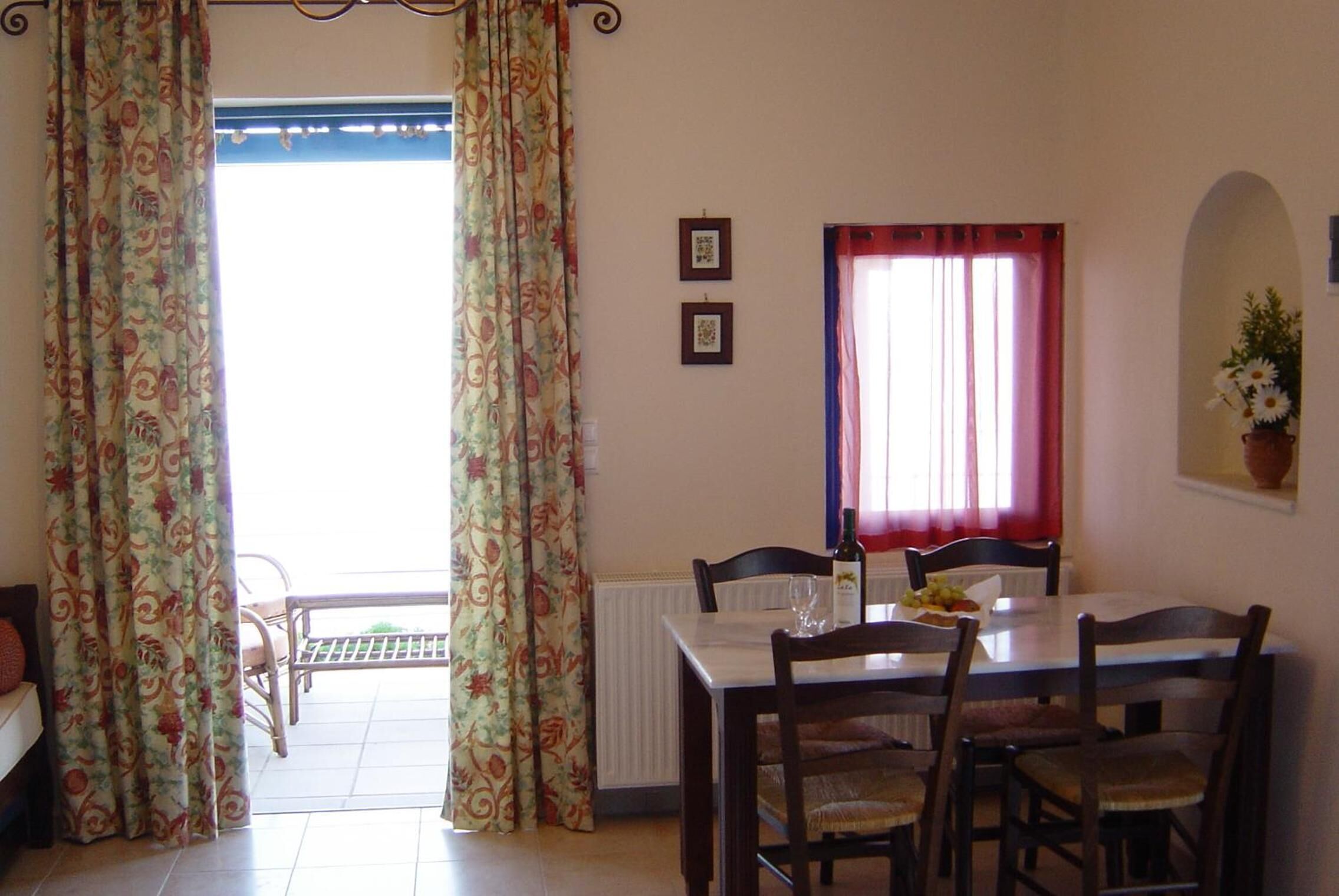 A dining area with a table, chairs, and a view of the outside.