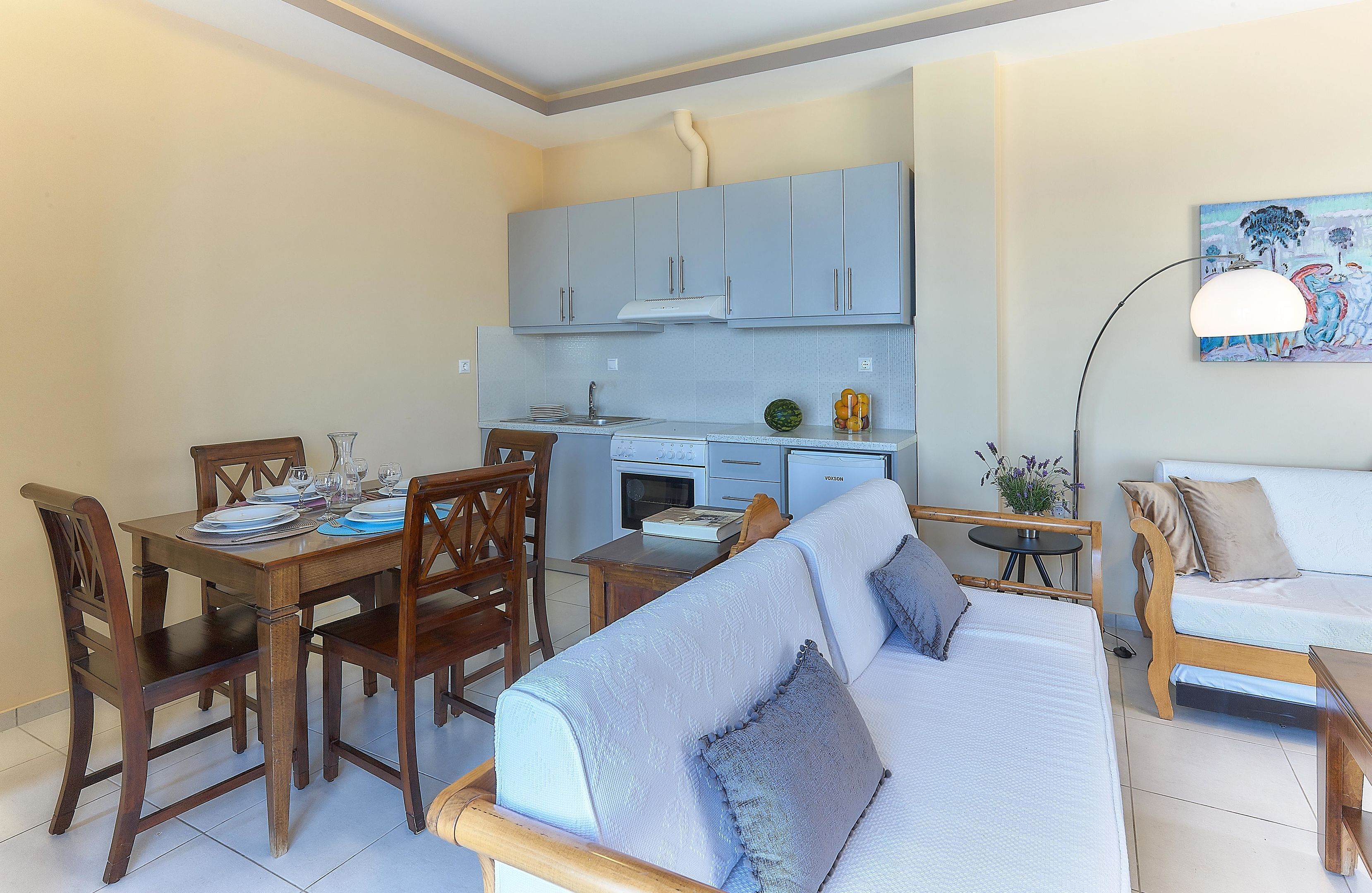 Un espace de vie compact comprenant un coin repas, une kitchenette et un canapé.